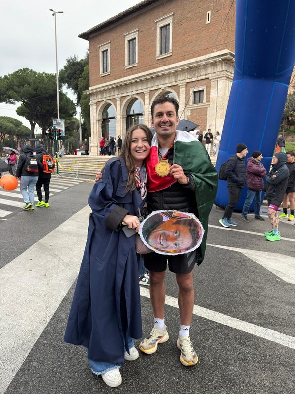 Rafa with a marathon medal and Eli cheering in Rome